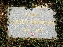 Une plaque commémorative sur un mur avec le légende « Ici passait la ligne de démarcation 1940-1943 »