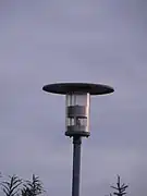 Lanterne contemporaineà base rondeposée sur un mat métallique