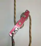 Descendeur de spéléologie monté sur corde, fermé.