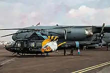 Un Bell CH-146 Griffon du 430e Escadron de l’Aviation royale canadienne décoré pour le Royal International Air Tattoo 2018. Derrière lui, un McDonnell Douglas C-17 Globemaster III.