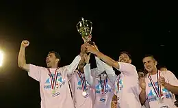Quatre joueurs d'Evian Thonon-Gaillard soulevant le trophée de championnat de National.
