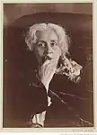 Félix Nadar et Paul Nadar, Ernestine Nadar drapée dans un velours sombre approchant un bouquet de violettes de son visage, vers 1890-1894.