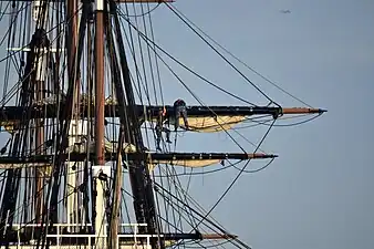 Gabier sur les vergues de l'USS&nbsp;Constitution. Les vergues sont mobiles horizontalement (pour l'orientation par rapport au vent) et verticalement (surtout les vergues hautes).