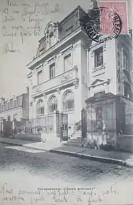 Façade principale vue latéralement depuis la rue, au tournant du XXe&nbsp;siècle.