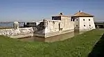 Côté sud-ouest, la structure à droite de la guérite en pierre, au milieu du rempart, au-dessus du fossé, "les latrines"