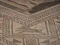 Photographie d'un détail de mosaïque polychrome représentant un sanglier.