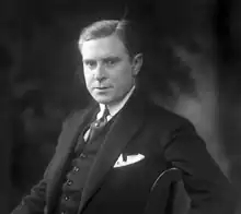 Photographie en noir et blanc du buste d'un homme vu de trois quart, le regard tourné vers l'objectif.