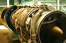 Vue rapprochée d'un CJ805-23. On distingue nettement la particularité de ce turbofan : l'emplacement arrière de la soufflante (aft fan). En arrière de celle-ci, on entrevoit les volets déployés de l'inverseur de poussée.