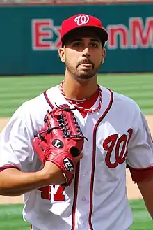Portrait d'un joueur de baseball tirant la langue, portant un gant de baseball rouge.