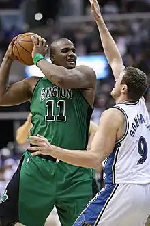 Le joueur des Celtics de Boston Glen Davis (no 11) protégant le ballon de basket-ball du défenseur des Wizards de Washington Darius Songaila (no 9)