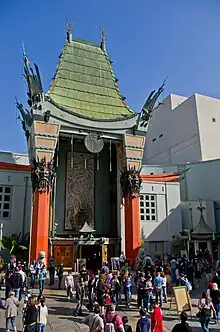 Photo d'un bâtiment dont la forme de l'entrée prend une architecture chinoise. Beaucoup de personnes pénètrent dans ce lieu.