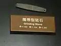 Pierre à affûter pouvant être portée, suspendue par une corde (autour du cou ?). 6,8&nbsp;×&nbsp;1,3&nbsp;×&nbsp;0,3&nbsp;cm. IIe – Ve&nbsp;siècle env. Shisanhang Museum