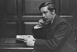 À un bureau, homme de profil moustachu, avec une raie, assis. Main droite soutient visage, gauche tient manuscrit.