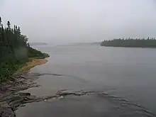 Photo de l'embouchure d'une rivière. Le ciel est gris en raison du brouillard.