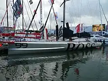 Vu de trois quarts avant, voilier argenté amarré à un ponton.