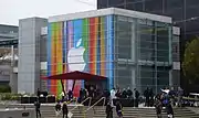 Bâtiment couvert d'un drapeau coloré avec le sigle Apple.