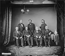 Photographie de sept hommes dont quatre sont assis.