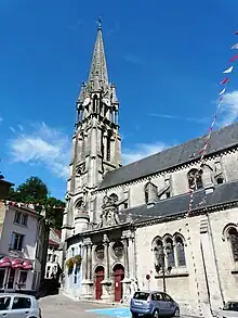 Église de style gothique surmontée d'un haut clocher.