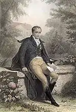 Gravure en couleur montrant Joseph Bonaparte assis sur un muret et tenant dans sa main gauche un livre ouvert.