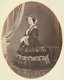 de profil et portant une robe à crinolines, Joséphine, les cheveux séparés en deux bandeaux, regarde l'objectif, l'air mélancolique