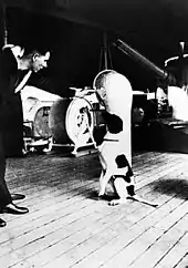 Un marin parle à un chien assis sur le pont d'un bateau.