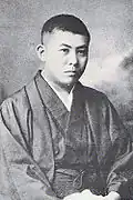 Photo d'homme en costume traditionnel japonais, regardant vers la droite.