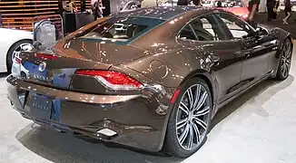 Photo de 2/4 face arrière d'une voiture de luxe marron dans un stand d'exposition.