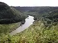 Vue de la rivière Wailu depuis le heiau de Poliʻahu, village de Kamokila (à droite) et grotte des Fougères.