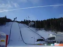 Un tremplin de saut à ski enneigé vu de face