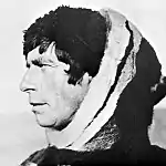 Photographie en noir et blanc et de profil d'un homme vêtu d'un habit polaire.