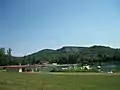 Au premier plan, le chalet d'accueil avec l'aquaparc, en arrière plan, la plage et le restaurant.