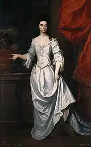Portrait en pied d'une élégante jeune femme brune, en longue robe blanche