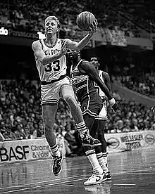 Photo en noir et blanc d'un joueur tentant un lay-up.