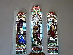 Le triptyque des vitraux du chœur. L'annonciation est représenté sur les vitraux droite et gauche. Au centre, est représenté saint Jean le Baptiste