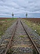 Vue de la ligne depuis le PN 33, sur sa section encore exploitée entre Pithiviers et Engenville.