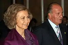 Photographie d'un couple, dont la femme porte un foulard violet et le mari un costume et une cravate.
