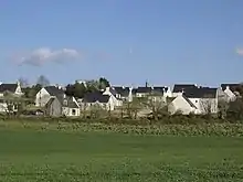 Lotissement de maisons de construction récente, aux toits d'ardoises bleue et aux murs blancs