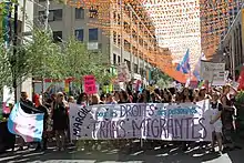 Une foule de gens derrière une bannière qui se lit «&nbsp;marche pour le droit des personnes trans migrantes&nbsp;»