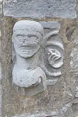 Fichée dans le mur extérieur du bas-côté sud, cette tête sculptée provient des fonts baptismaux mosans du XIIIe&nbsp;siècle disparus.