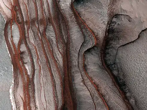 Strates sur les pentes de Chasma Boreale, vallée qui s'enfonce dans la calotte polaire. L'image fait 1&nbsp;km de droite à gauche et la dénivelée est également de 1&nbsp;km.