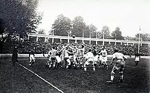 Photographie montrant les joueurs se disputant le ballon sur le terrain.
