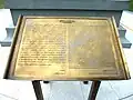 La plaque devant la statue.