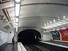 Vue du tympan de la station Notre-Dame-des-Champs avec la direction d'origine en faïence "Direction Montmartre".