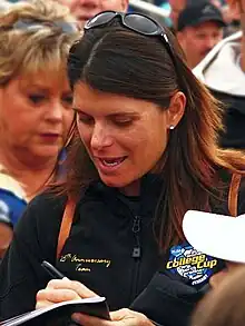 portrait en buste d'un femme signant un autographe.