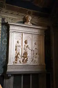 Retable sculpté en marbre. Un triptyque représente sur chacun des volets un adulte avec un bébé à ses pieds.