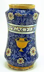 Albarello à décor de graffiti sur fond bleu se terminant par des marguerites, des coupes et un cartouche pharmaceutique, Montelupo, première moitié du XVIe&nbsp;siècle.