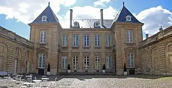 Photographie d'un bâtiment entourant une cours de gravier.
