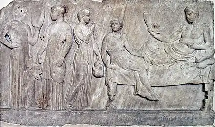 Relief en marbre, représentant Dionysos (à droite) et des acteurs tenant des masques (à gauche), voué au dieu après une représentation. Le Pirée, v.&nbsp;400 av. J.-C. Musée national archéologique d'Athènes.