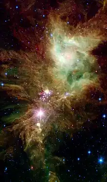 NGC 2264 en infrarouge par le télescope spatial Spitzer. En rose, des étoiles nouvellement formées. On a donné le nom d'amas du Flocon de Neige&nbsp;(en) au groupe d'étoiles que l'on voit sur cette photo.