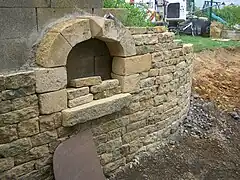 Mur en moellon avec une niche en pierre de taille.